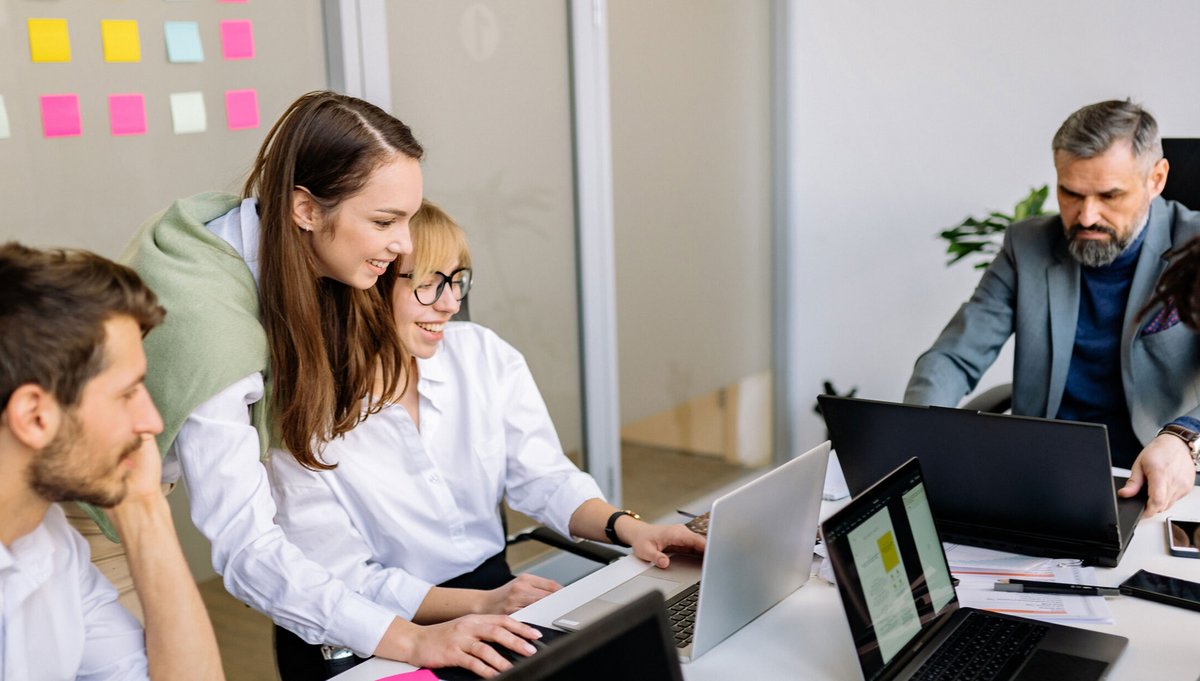 Eine Frau zeigt den anderen Workshop Teilnehmern etwas am Computer